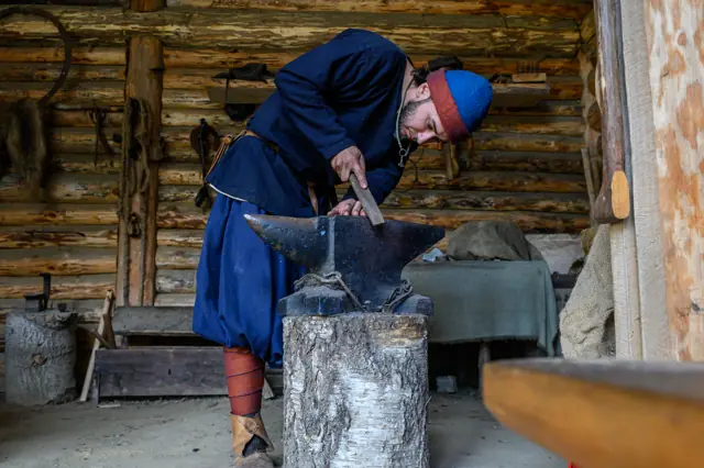 Кузнец куёт на наковальне